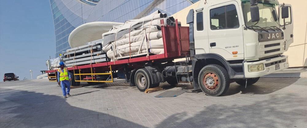 Flatbed truck loaded with pipes at Lusail