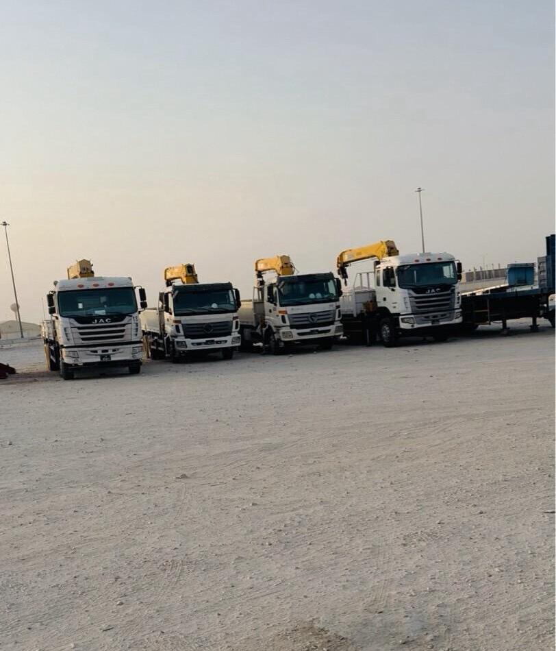 Fleet of boom trucks parked in the desert